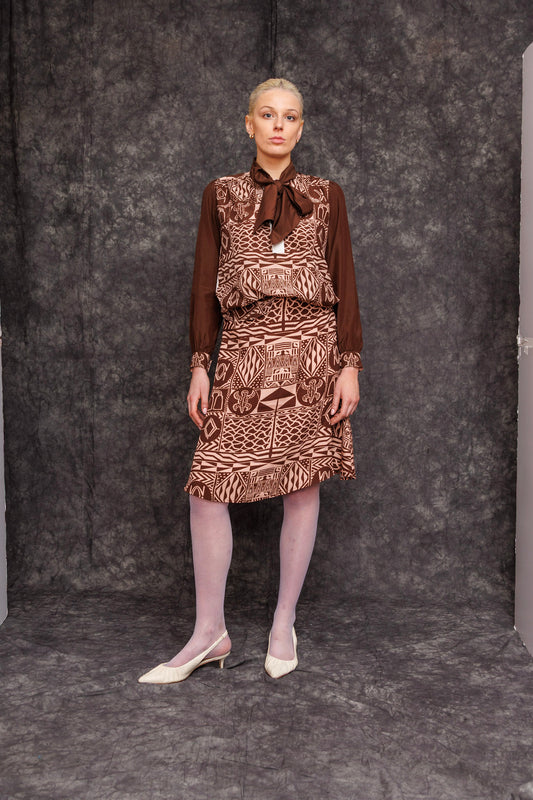 Model wearing Kadji Teo Toned Mocca Blouse styled with skirt, front view