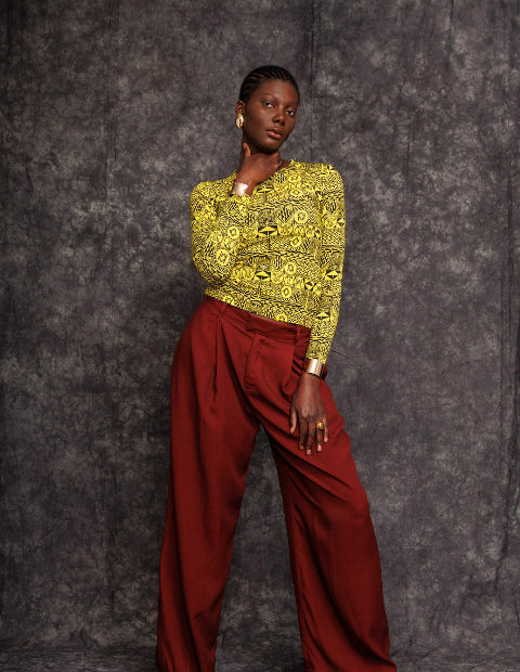 Lifestyle shot of model in bold printed top and burgundy pants