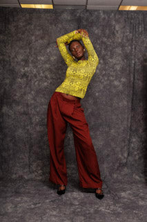 Model wearing Njapou Wide-Leg Pants in burgundy with yellow top